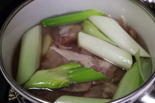 鶏肉、しょうが、長ネギと水でお鍋で煮ているところ