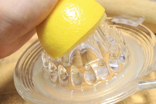 レモンをレモン絞り器で絞っている過程